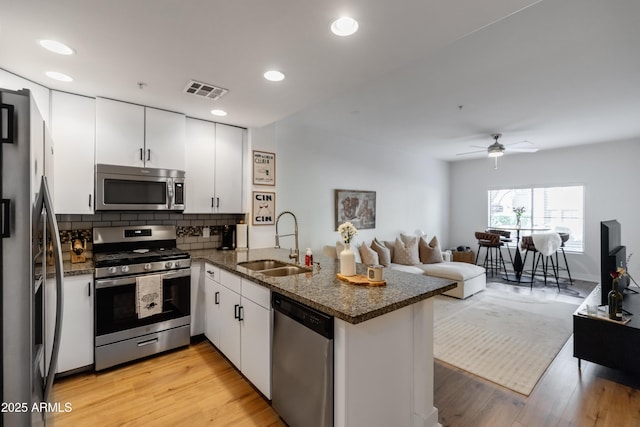 kitchen featuring sink, white cabinets, appliances with stainless steel finishes, and kitchen peninsula