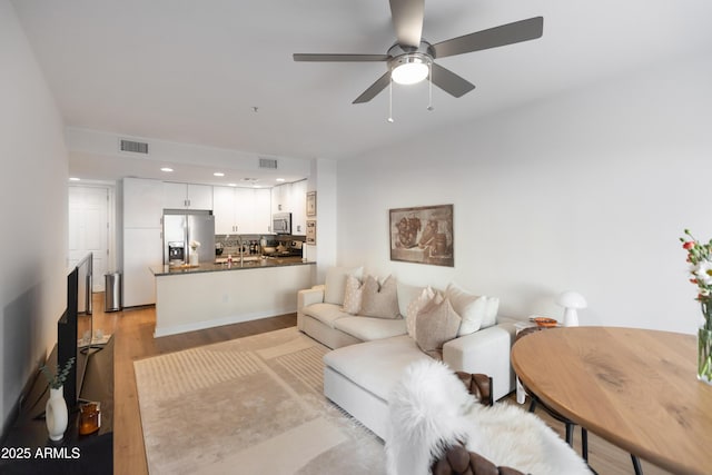 living room featuring ceiling fan and light wood-type flooring