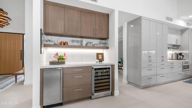 5438 E Lupine Ave, Scottsdale, AZ 85254 - indoor bar featuring wine cooler, oven, light tile patterned floors, tasteful backsplash, and fridge