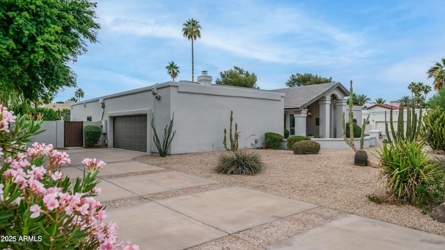 5438 E Lupine Ave, Scottsdale, AZ 85254 - mid-century modern home featuring a garage, stucco siding, driveway, a gate, and a chimney