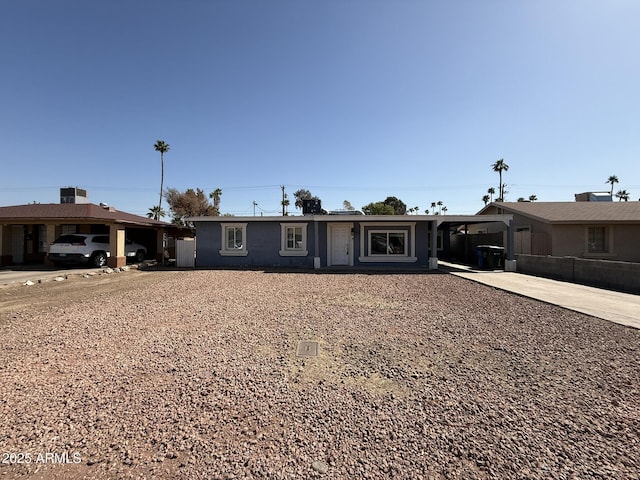 ranch-style home with concrete driveway and fence