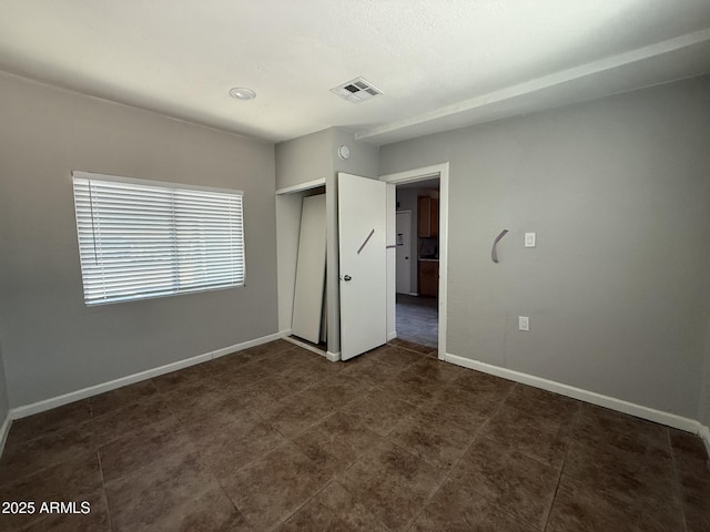 unfurnished bedroom with a closet, visible vents, and baseboards