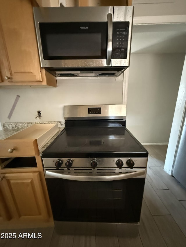 kitchen with appliances with stainless steel finishes, light brown cabinets, and dark wood finished floors