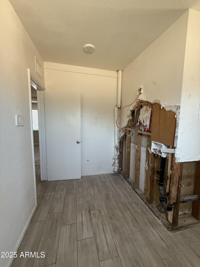 hallway with wood finish floors and a textured ceiling