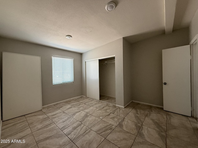 unfurnished bedroom with a textured ceiling and a closet