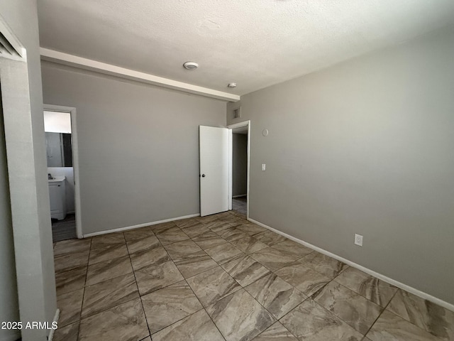 unfurnished bedroom with a textured ceiling, marble finish floor, visible vents, and baseboards