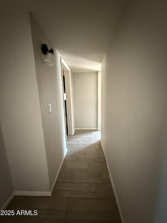 hall featuring wood tiled floor and baseboards