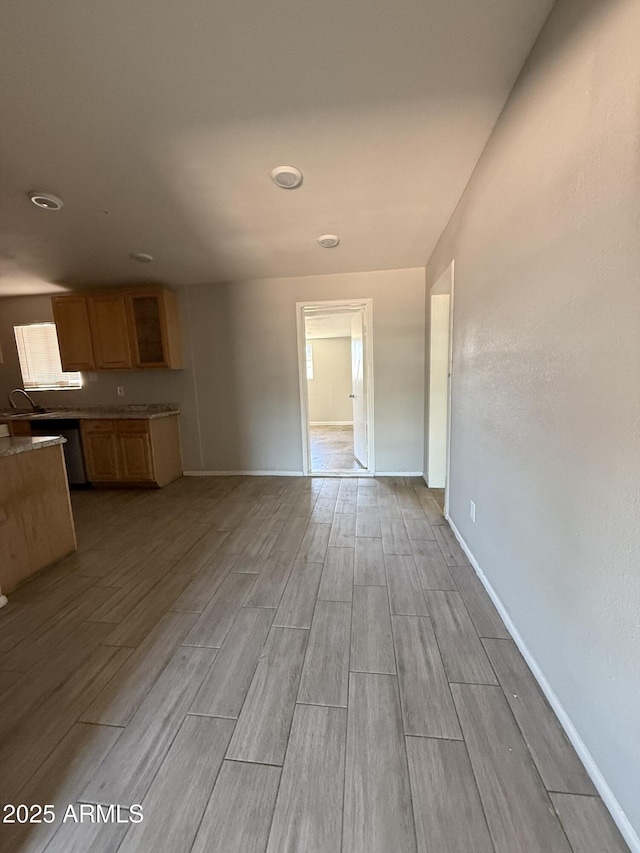 unfurnished living room with baseboards and wood tiled floor