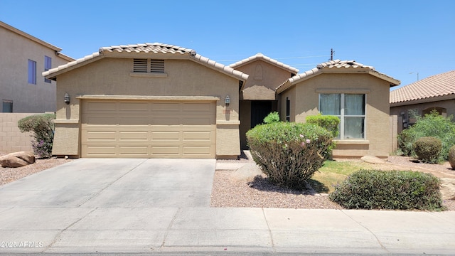 4432 W Pleasant Ln, Laveen, AZ 85339 - view of front of property featuring an attached garage, driveway, stucco siding, and a tiled roof