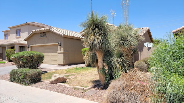 4432 W Pleasant Ln, Laveen, AZ 85339 - view of front facade with a tiled roof, a garage, and stucco siding