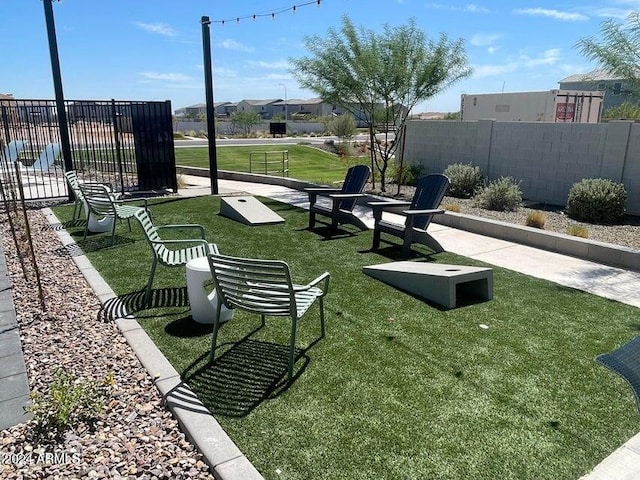 view of community featuring a lawn and fence