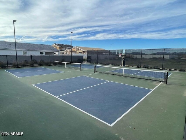 view of tennis court featuring fence