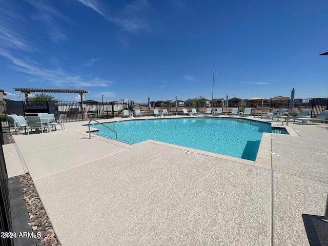 pool with fence, a pergola, and a patio area