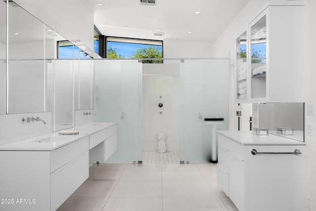 4218 E Palo Verde Dr, Phoenix, AZ 85018 - bathroom featuring double vanity, tiled shower, a sink, tile patterned floors, and visible vents