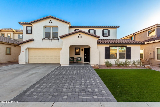 mediterranean / spanish-style home featuring a front yard and a garage