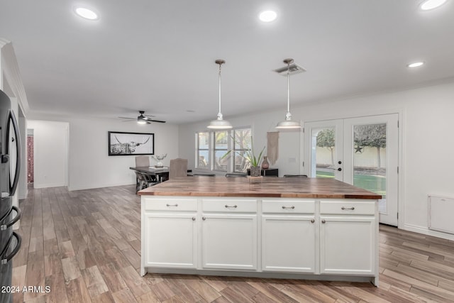 kitchen with decorative light fixtures, butcher block countertops, white cabinetry, and ceiling fan