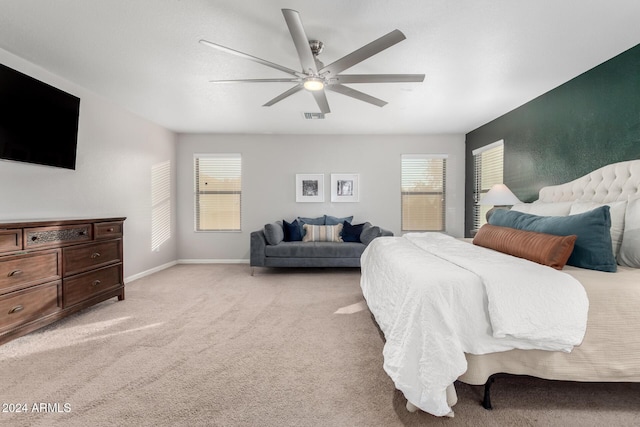 carpeted bedroom featuring ceiling fan and multiple windows