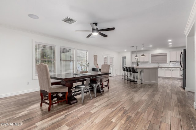 dining room with ceiling fan, sink, and ornamental molding