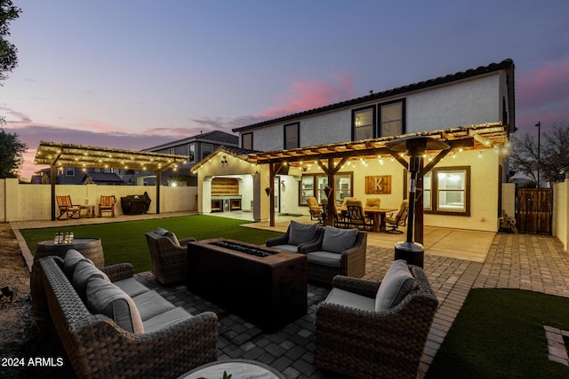 back house at dusk with a pergola, an outdoor living space with a fire pit, and a patio area