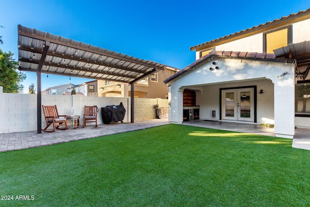 rear view of property featuring french doors, a yard, and a patio area