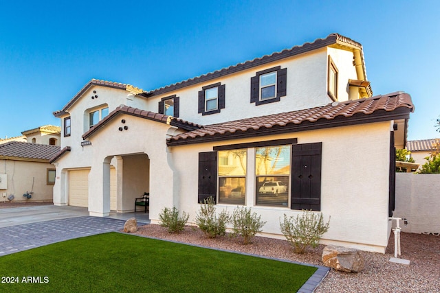 mediterranean / spanish home with a garage and a front yard