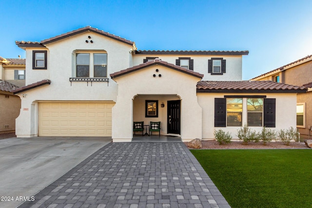 mediterranean / spanish home with a front yard and a garage