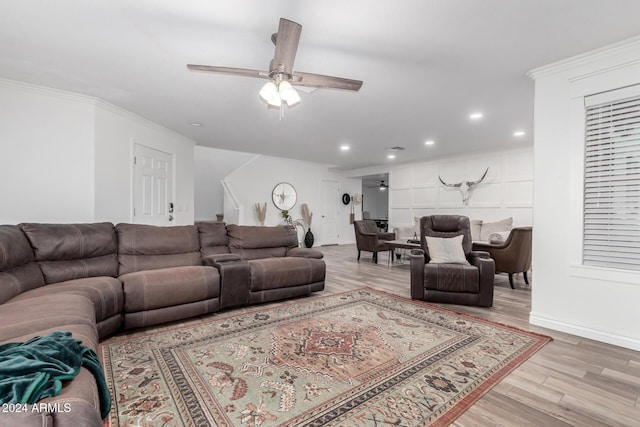 living room with ceiling fan, light hardwood / wood-style flooring, and ornamental molding