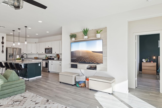 living room with ceiling fan and sink