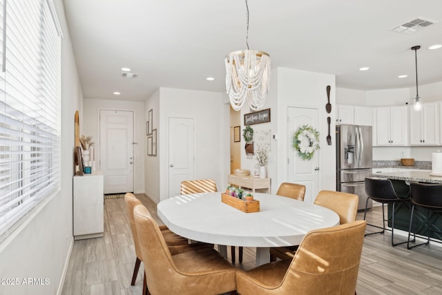 dining area with a chandelier and light hardwood / wood-style floors