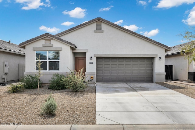 ranch-style house with a tile roof, stucco siding, an attached garage, and concrete driveway