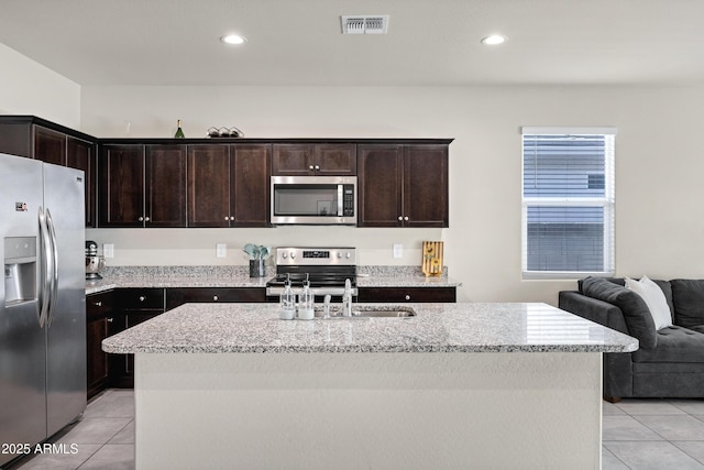 kitchen featuring light tile patterned floors, visible vents, appliances with stainless steel finishes, and light stone countertops