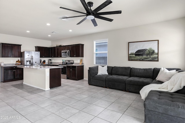 kitchen featuring ceiling fan, dark brown cabinetry, open floor plan, and stainless steel appliances