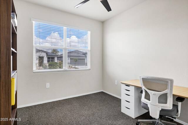 unfurnished office featuring a ceiling fan, baseboards, and dark carpet