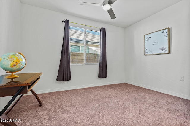 carpeted empty room with ceiling fan and baseboards