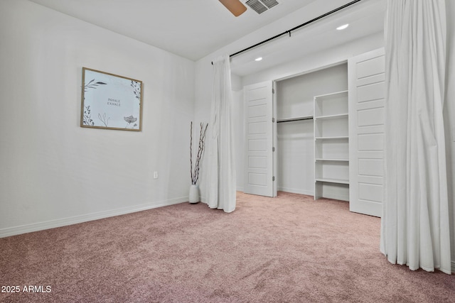 unfurnished bedroom featuring a closet, light colored carpet, visible vents, and baseboards