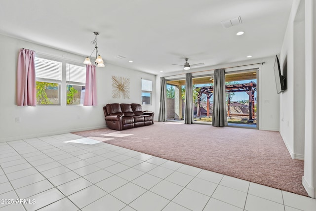 living area with a wealth of natural light, light colored carpet, and light tile patterned floors