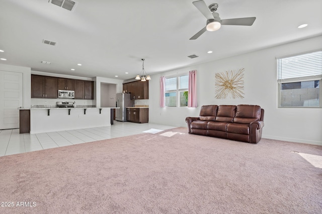 living area with recessed lighting, light carpet, and visible vents