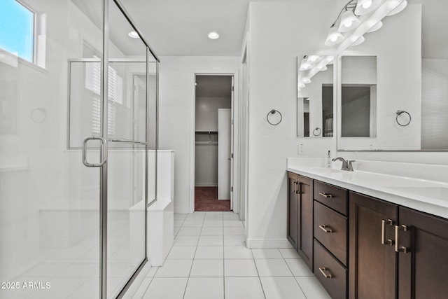 full bathroom with a shower stall, a walk in closet, tile patterned flooring, and vanity