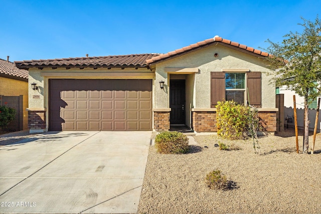 mediterranean / spanish house with concrete driveway, an attached garage, a tiled roof, and stucco siding