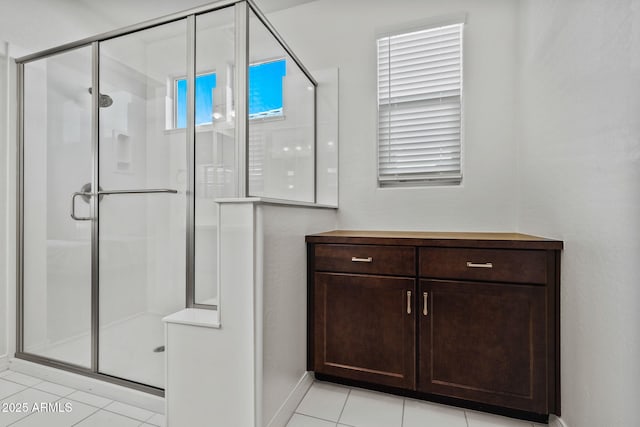 bathroom with a shower stall and tile patterned floors