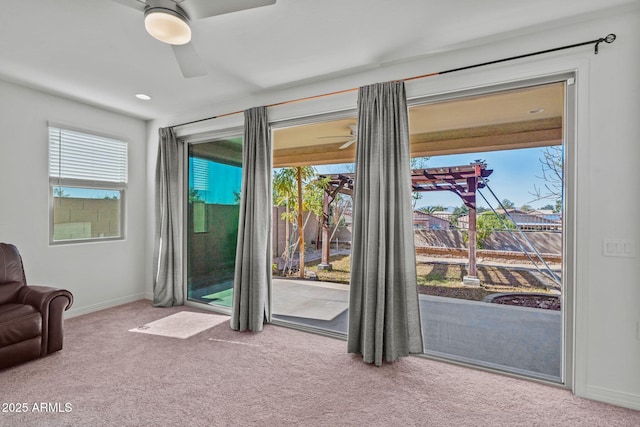 doorway to outside featuring light carpet, ceiling fan, and baseboards