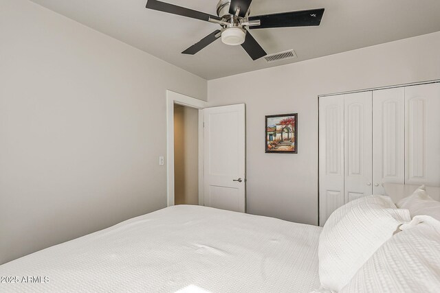 bedroom with visible vents, ceiling fan, and a closet