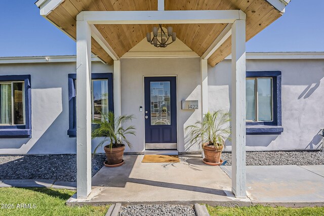 doorway to property featuring stucco siding