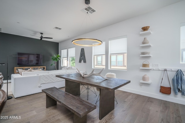 dining space featuring baseboards, ceiling fan, visible vents, and wood finished floors