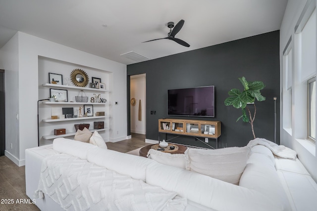 living room featuring baseboards, ceiling fan, visible vents, and wood finished floors