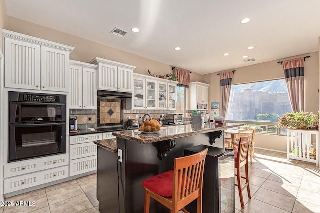 kitchen with black appliances, tasteful backsplash, visible vents, and light tile patterned floors