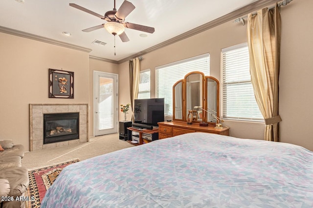 carpeted bedroom with a tiled fireplace, visible vents, multiple windows, and access to outside