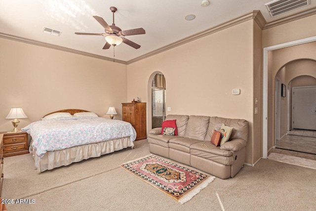 carpeted bedroom with visible vents, arched walkways, and ornamental molding