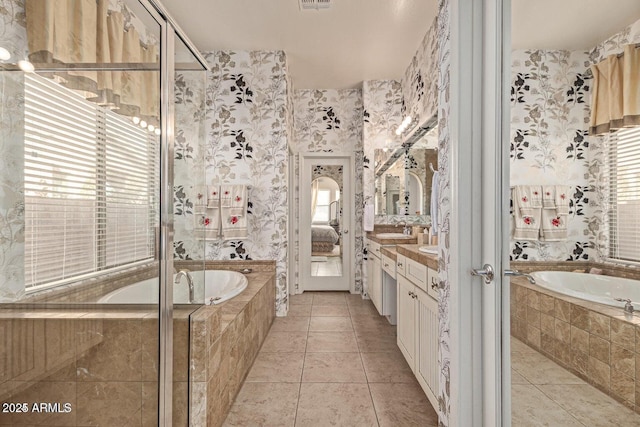 full bath with tile patterned flooring, vanity, and a garden tub