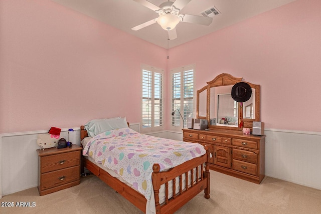 bedroom with a ceiling fan, visible vents, and light carpet